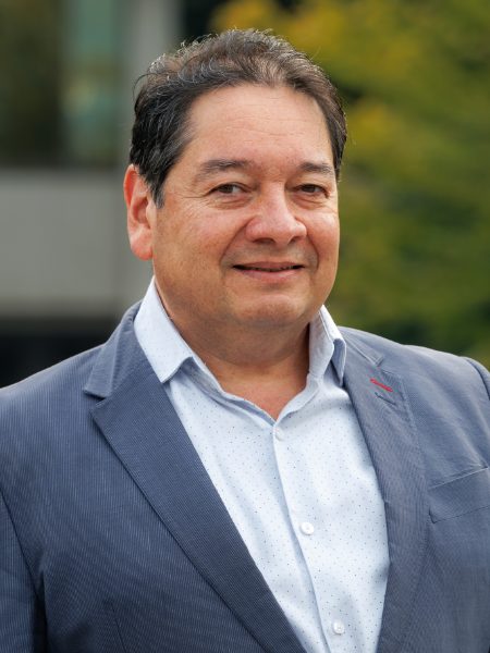 Humberto Morales smiling in a blue pinstriped blazer and light shirt, outdoors